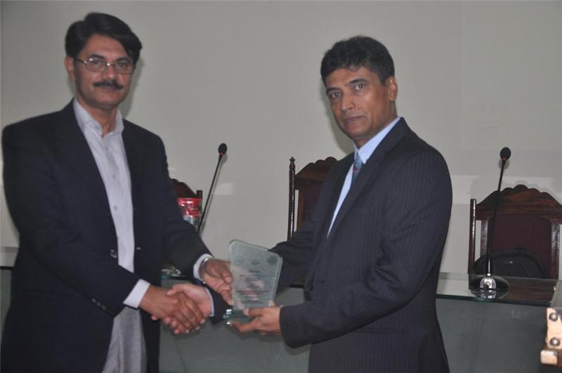 Prof. Dr. Naveed Ahsan of Punjab University presenting a gift to Syed Tariq Hasany