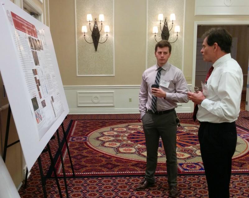 Caleb Bontempi discussing poster with attendee.